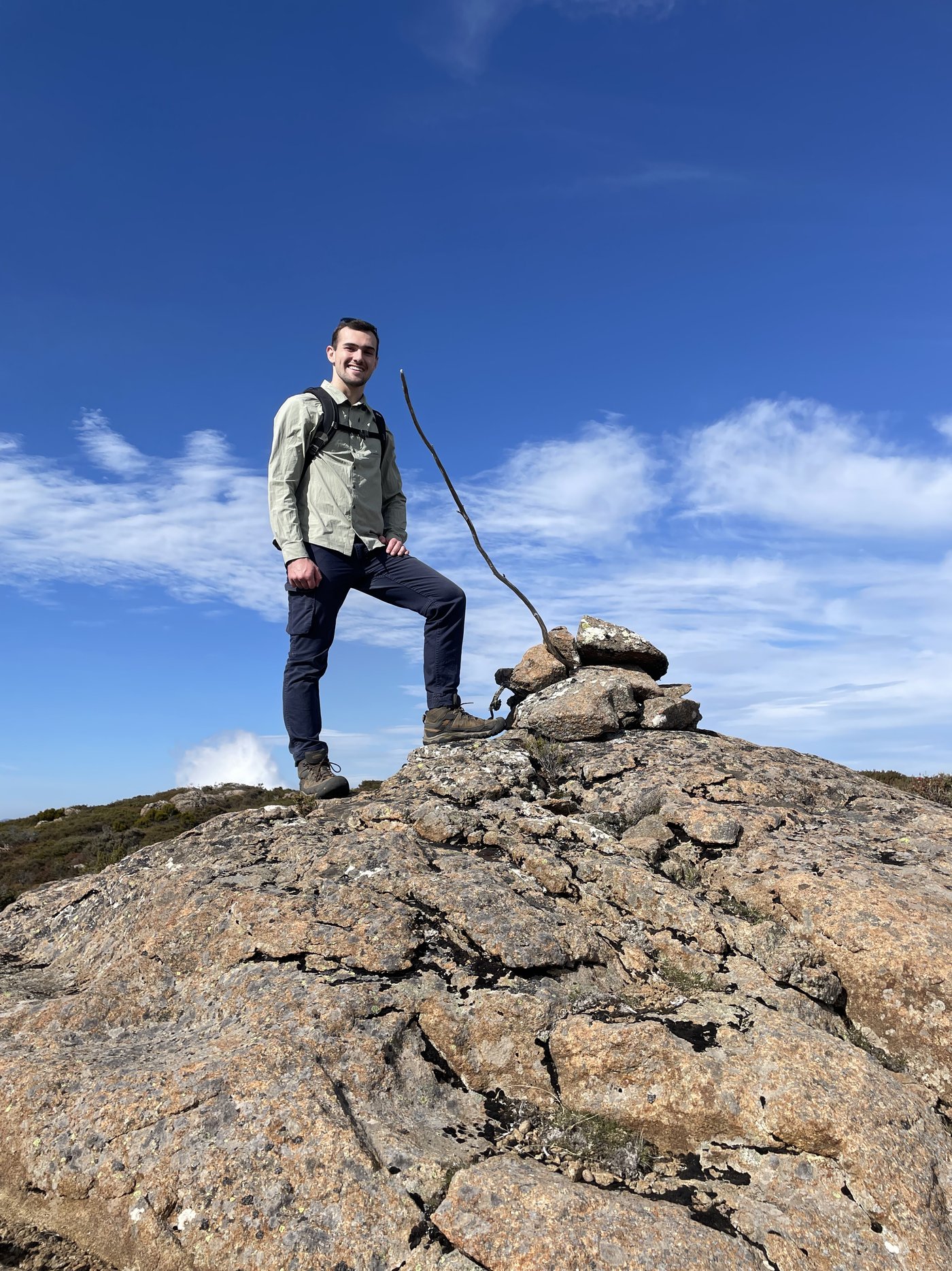 Joel Badcock standing on a granite summit in Tasmania
